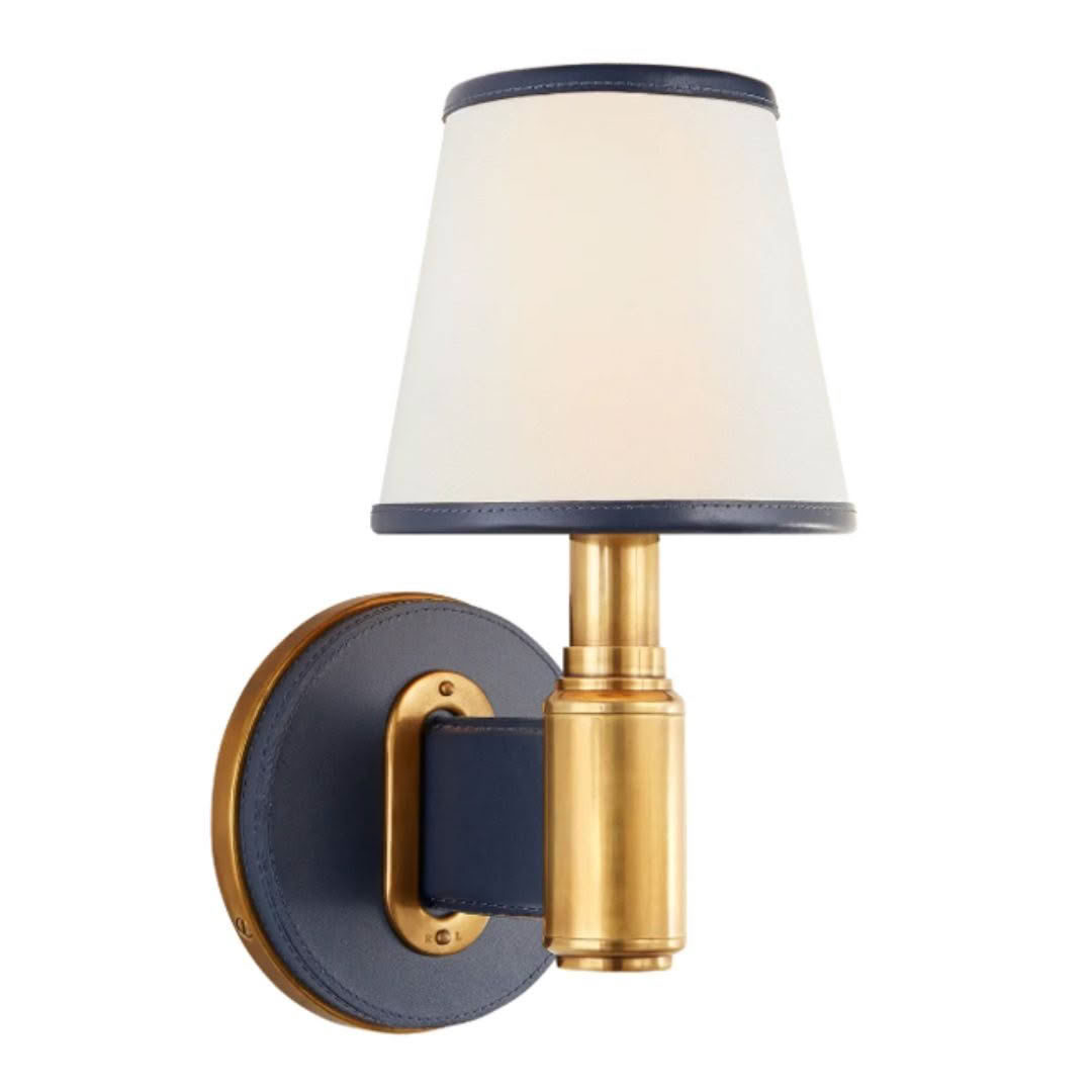 Brass sconce with navy mount and white shade