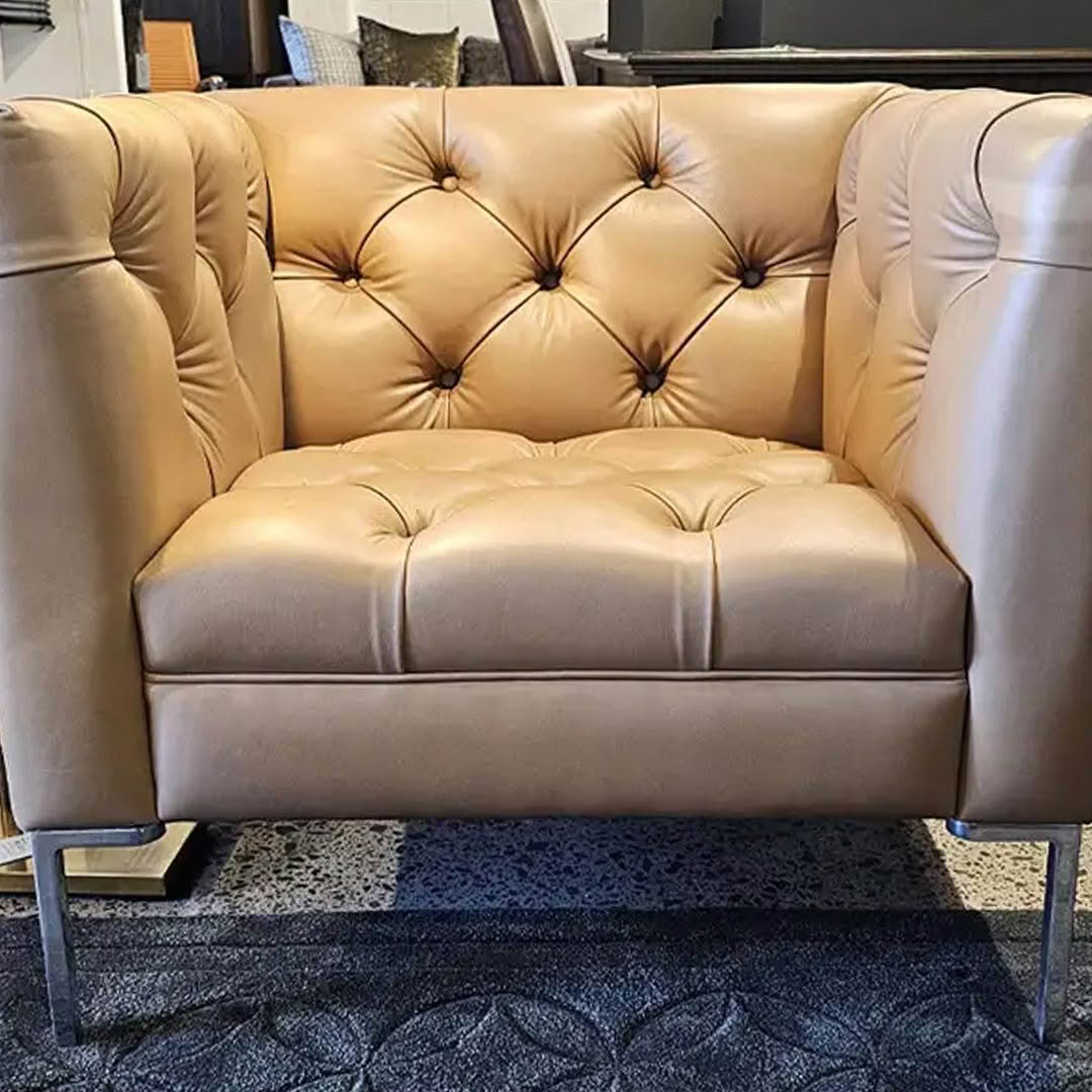 Beige tufted leather loveseat with sleek metal legs