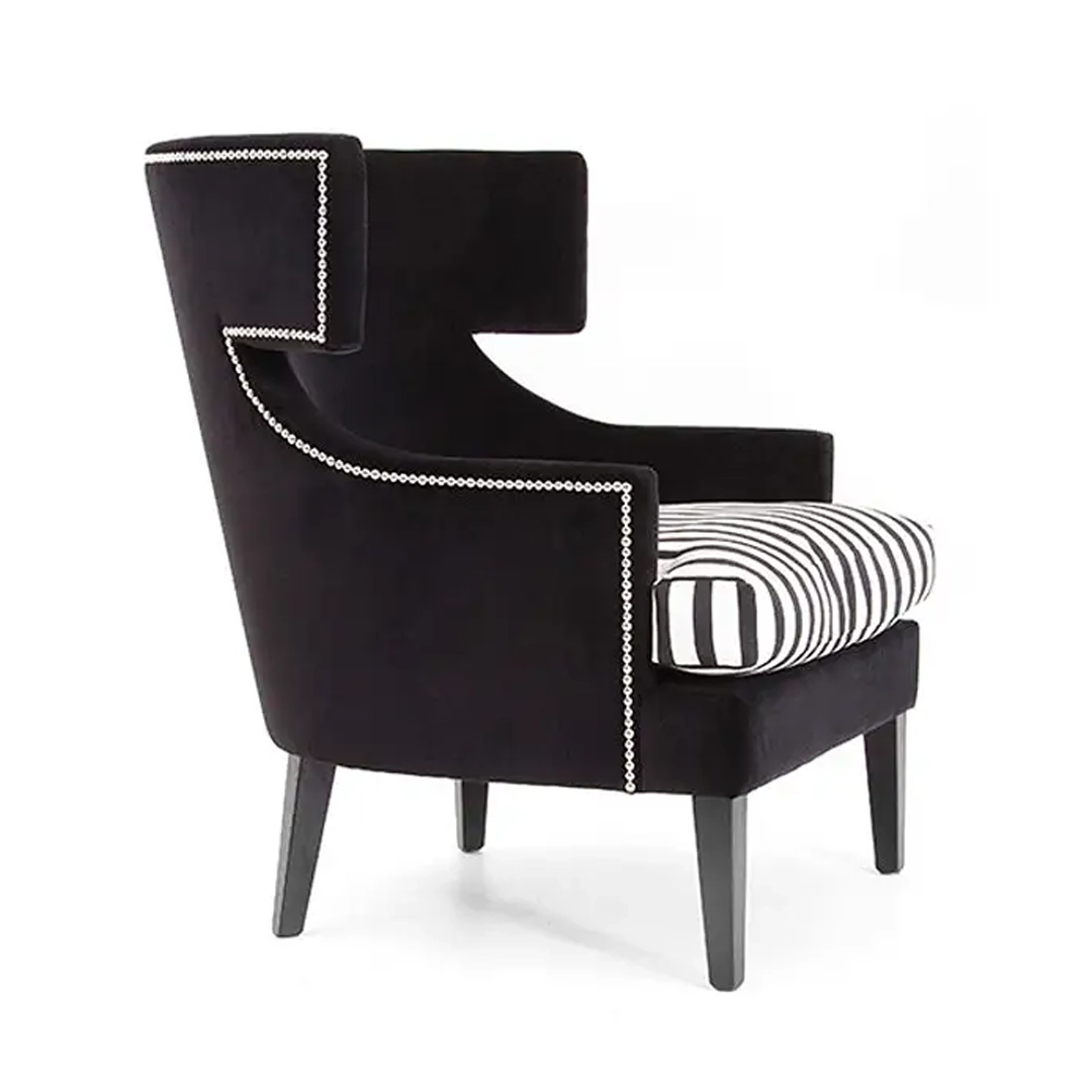 Elegant black armchair with white piping and striped cushion