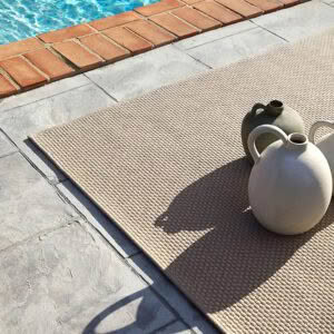 Outdoor rug by pool with two ceramic jugs