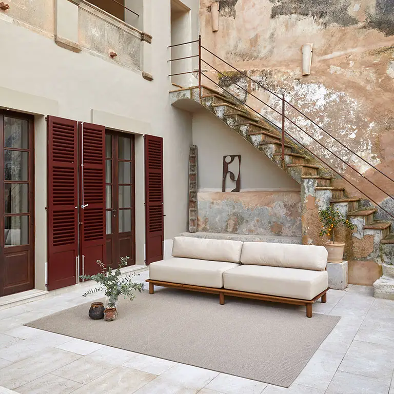 Outdoor beige sofa near rustic Mediterranean building