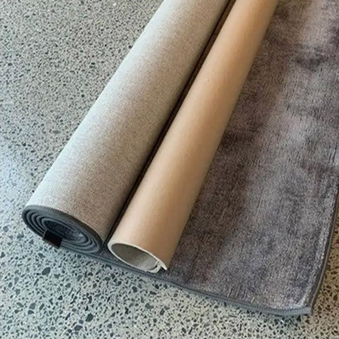 Rolled and partially unrolled gray area rugs
