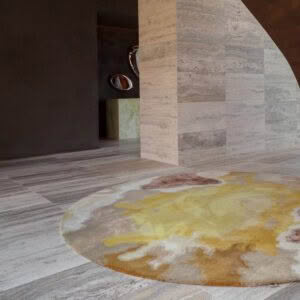 Modern interior with patterned rug and stone walls