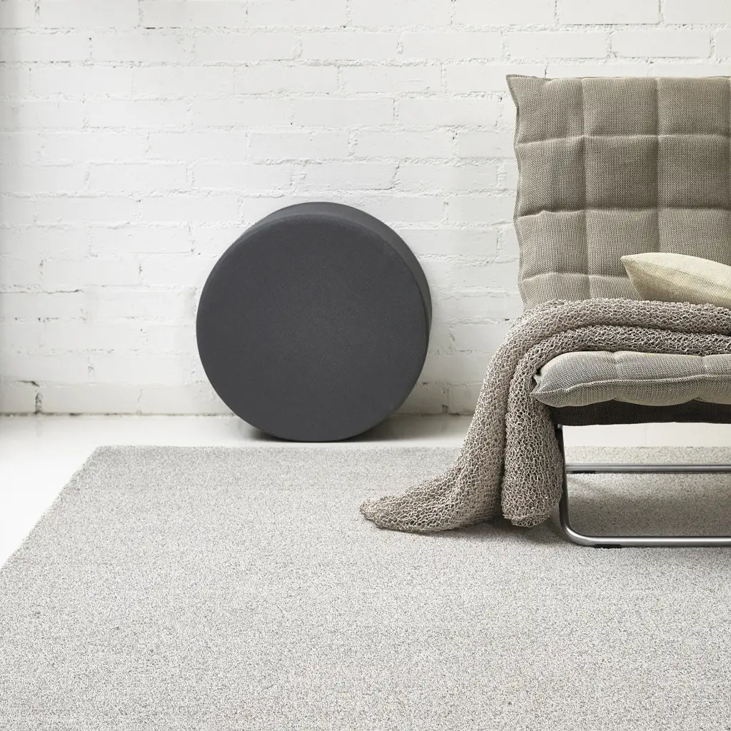 Modern minimalist interior with a gray round pouf
