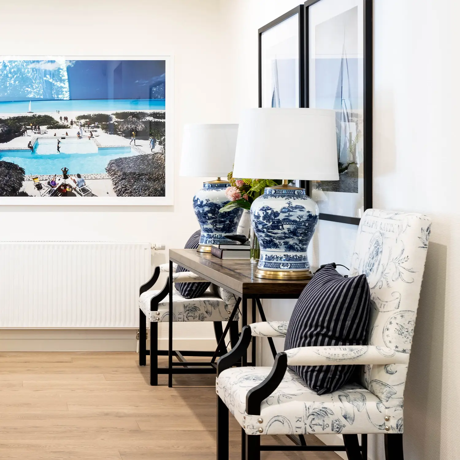 Elegant interior with framed beach photos and ceramic lamps