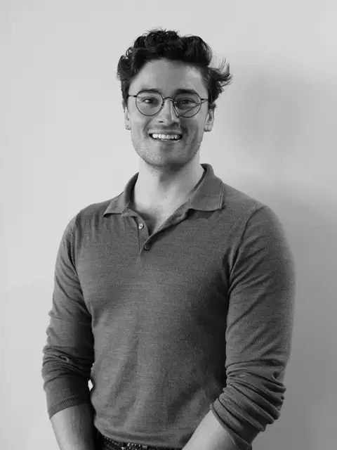 Smiling young man with glasses in grayscale portrait
