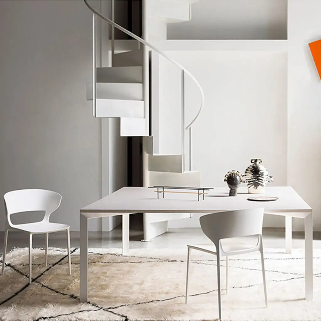 Modern minimalist interior with table, chairs, and staircase