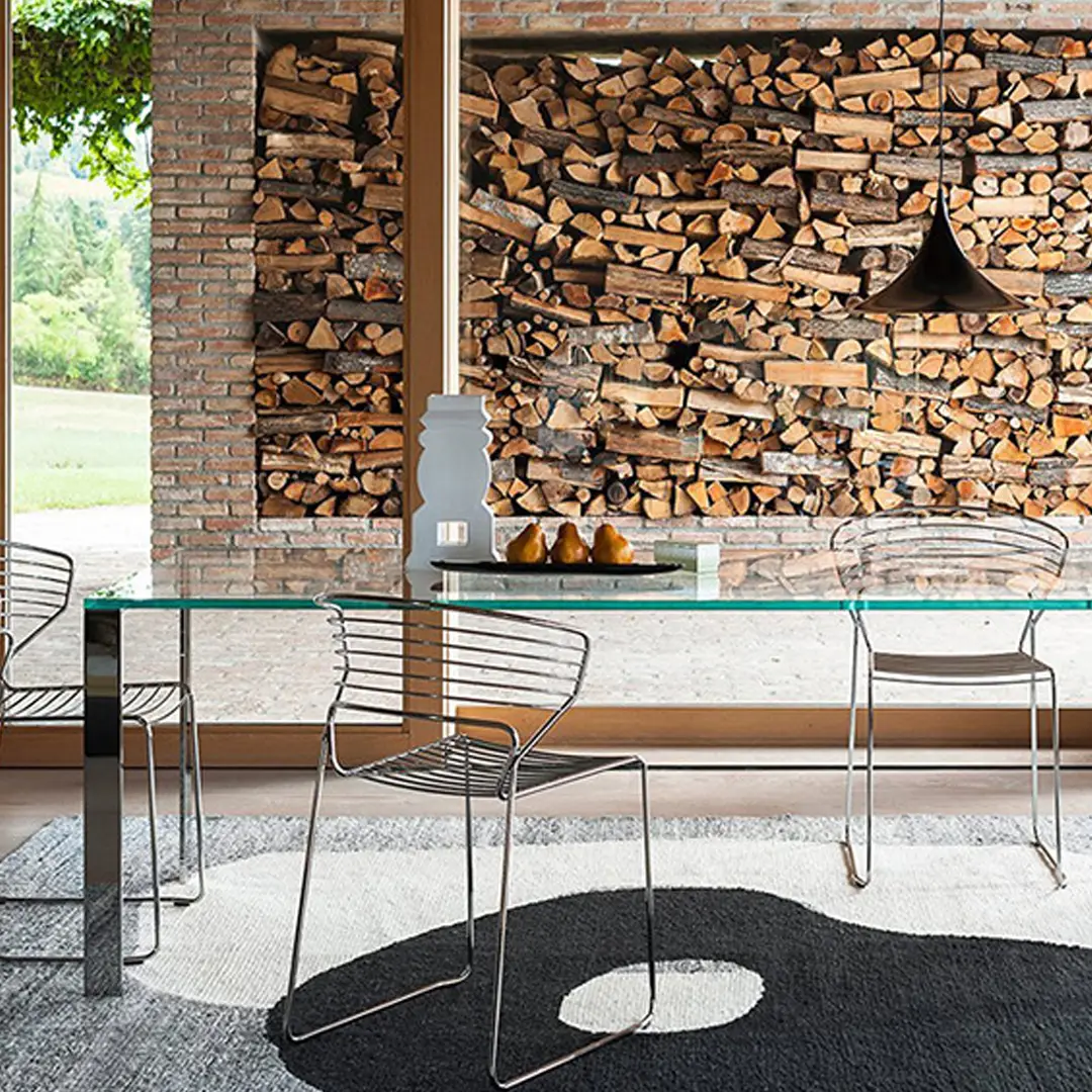 Modern dining room with wood firewood wall and glass table