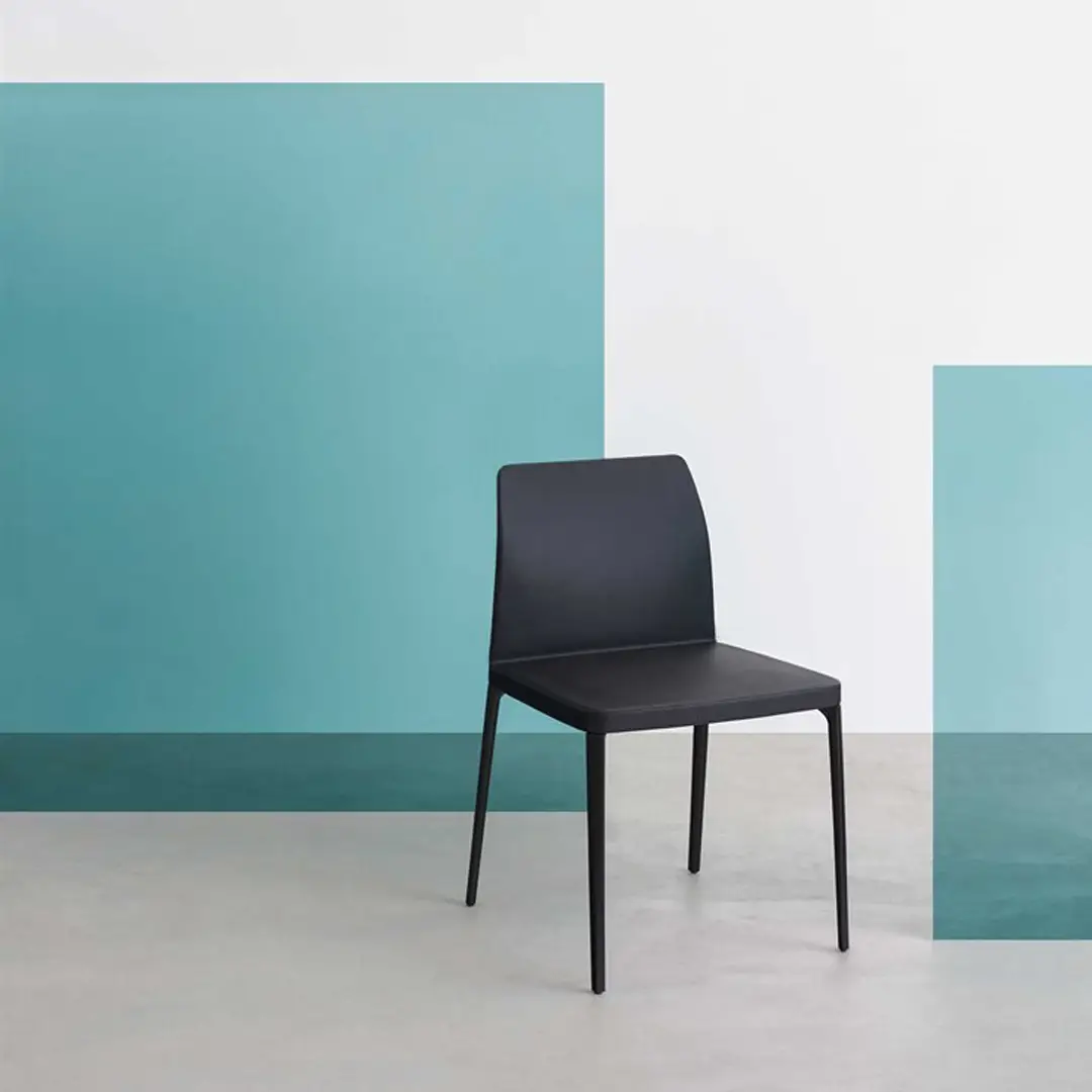 Modern black chair against turquoise geometric background