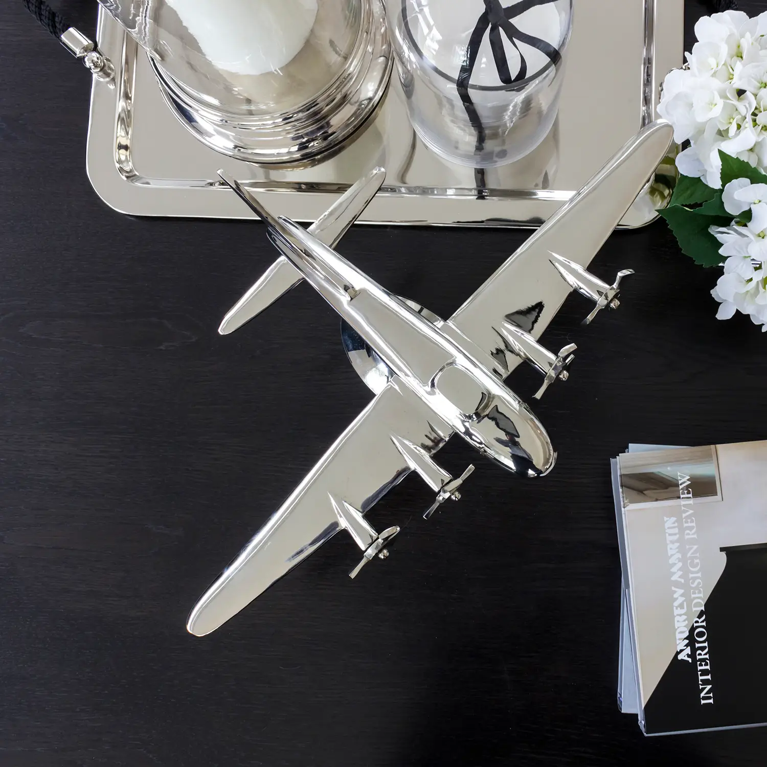 Silver airplane model on black reflective surface