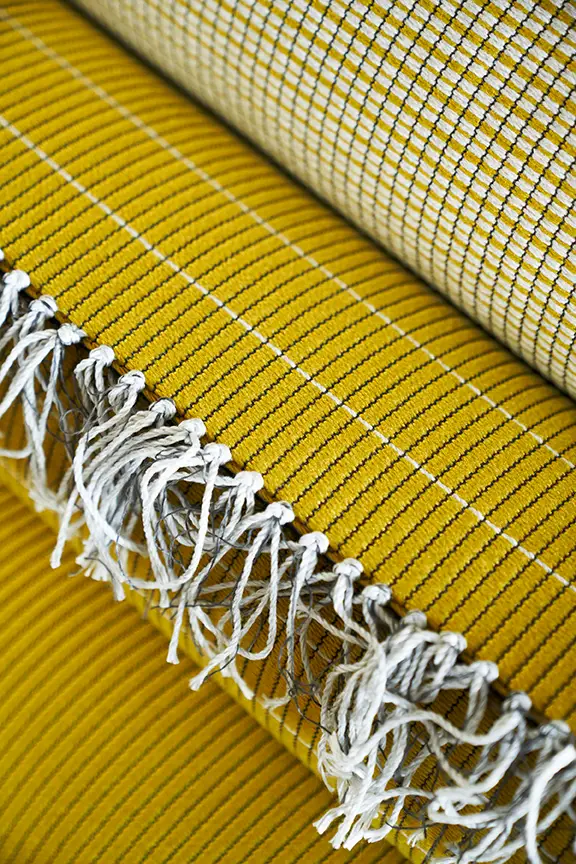 Yellow patterned woven textile with fringe detail