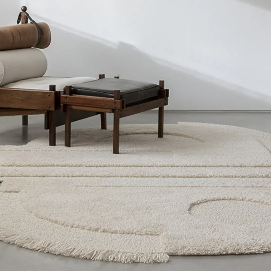 Modern lounge chair and round textured rug in room.