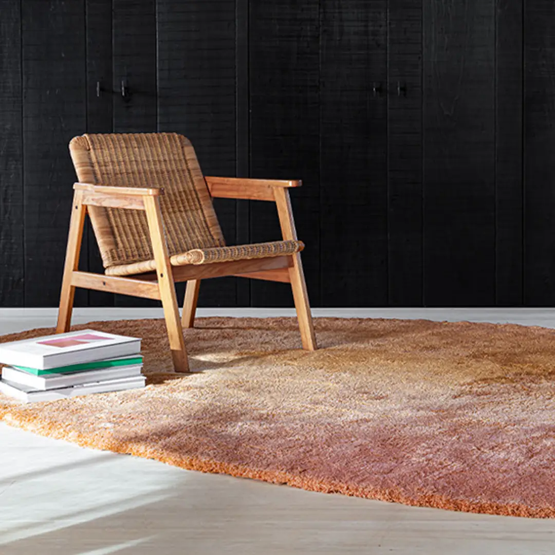 Woven rattan chair on textured rug in dark room