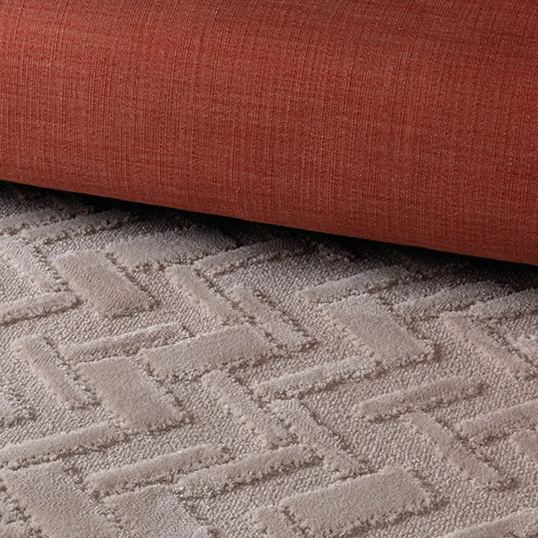 Orange sofa on textured gray carpet.