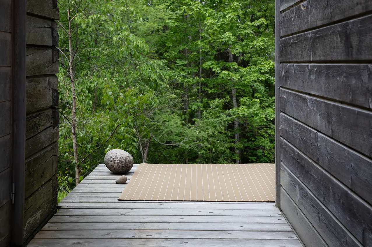 Wooden deck with stone ball surrounded by lush forest