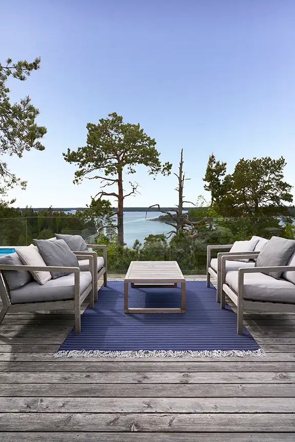 Outdoor patio with seating overlooking tranquil lake view
