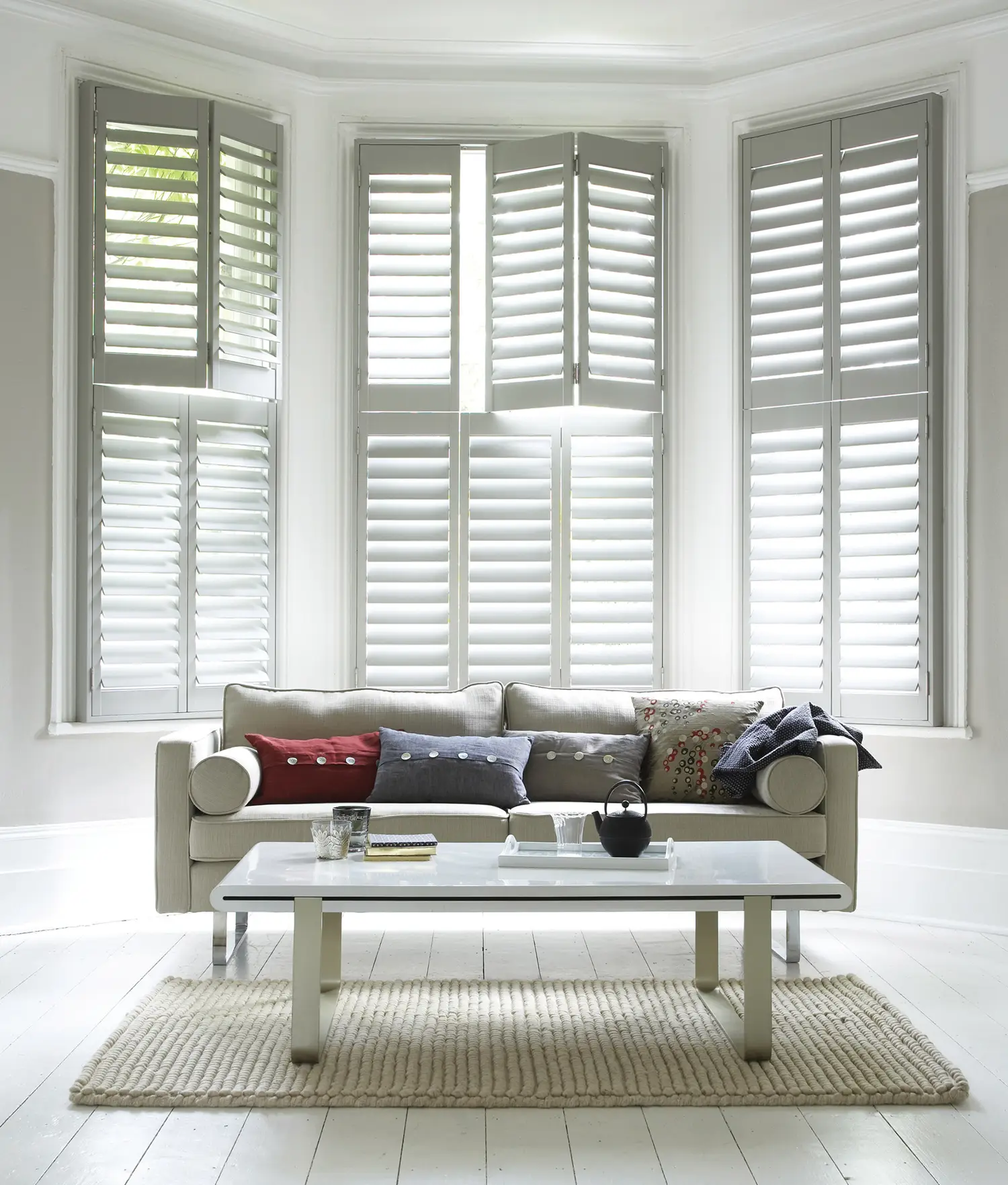 Bright living room with modern sofa and stylish shutters