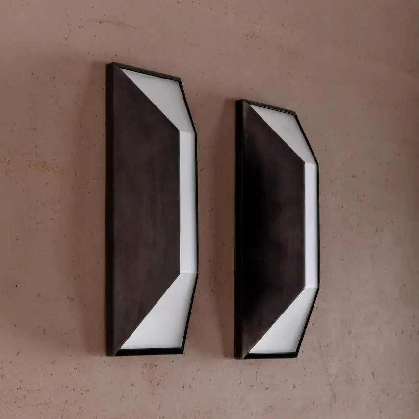 Two geometric wall lamps on textured pink wall