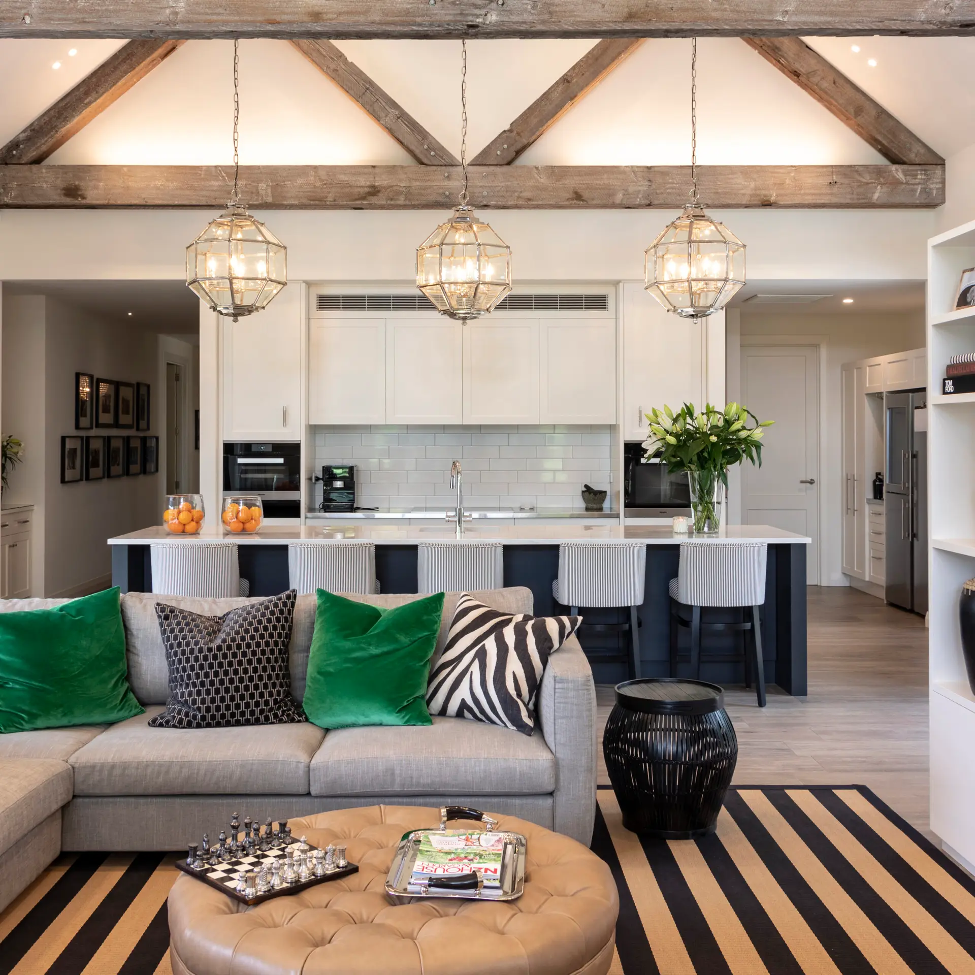 Stylish living room with kitchen, modern decor, and exposed beams