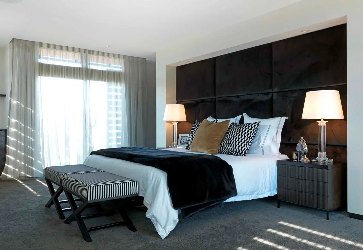 Elegant modern bedroom with sunlight through sheer curtains