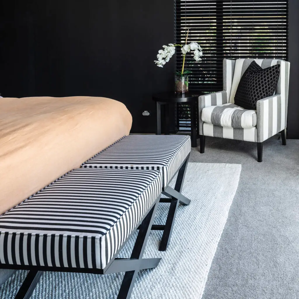Elegant bedroom with striped benches and modern chair