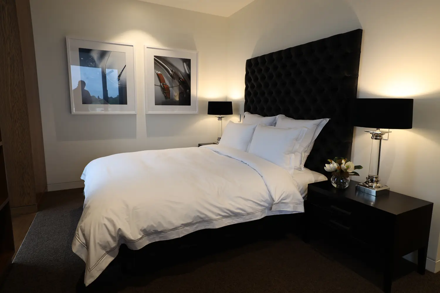 Modern bedroom with black headboard and framed art