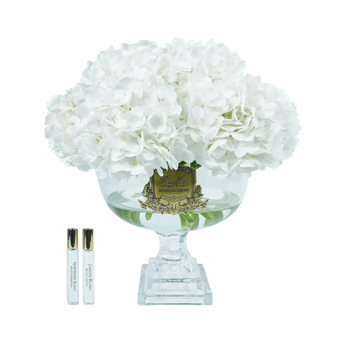 White hydrangeas in vase with perfume samples