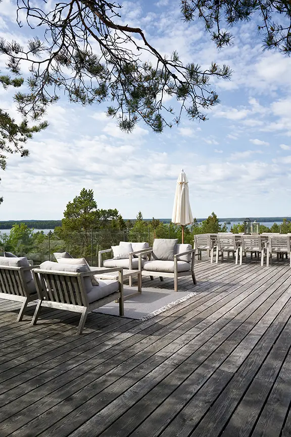 Outdoor deck with furniture overlooking serene lake