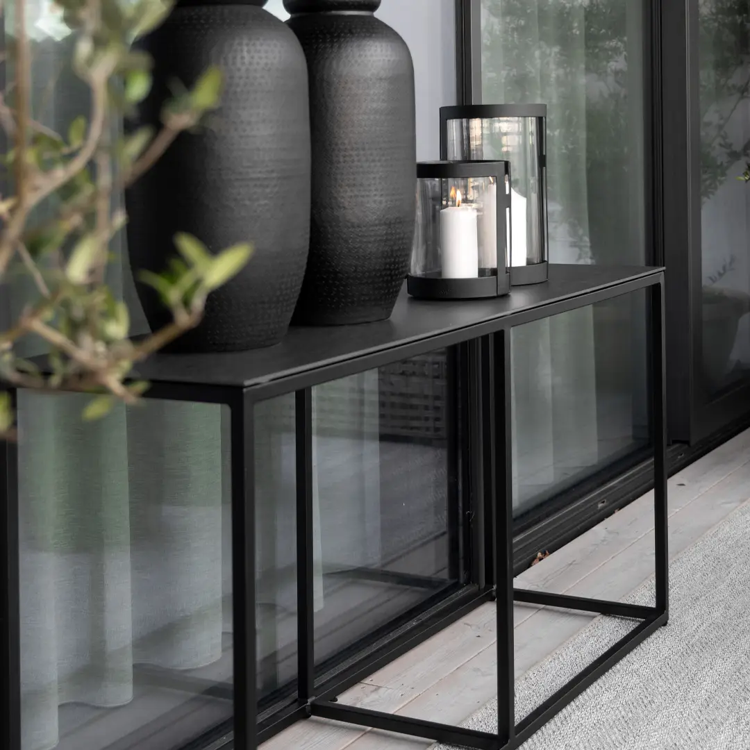 Modern console table with decorative black vases and lantern