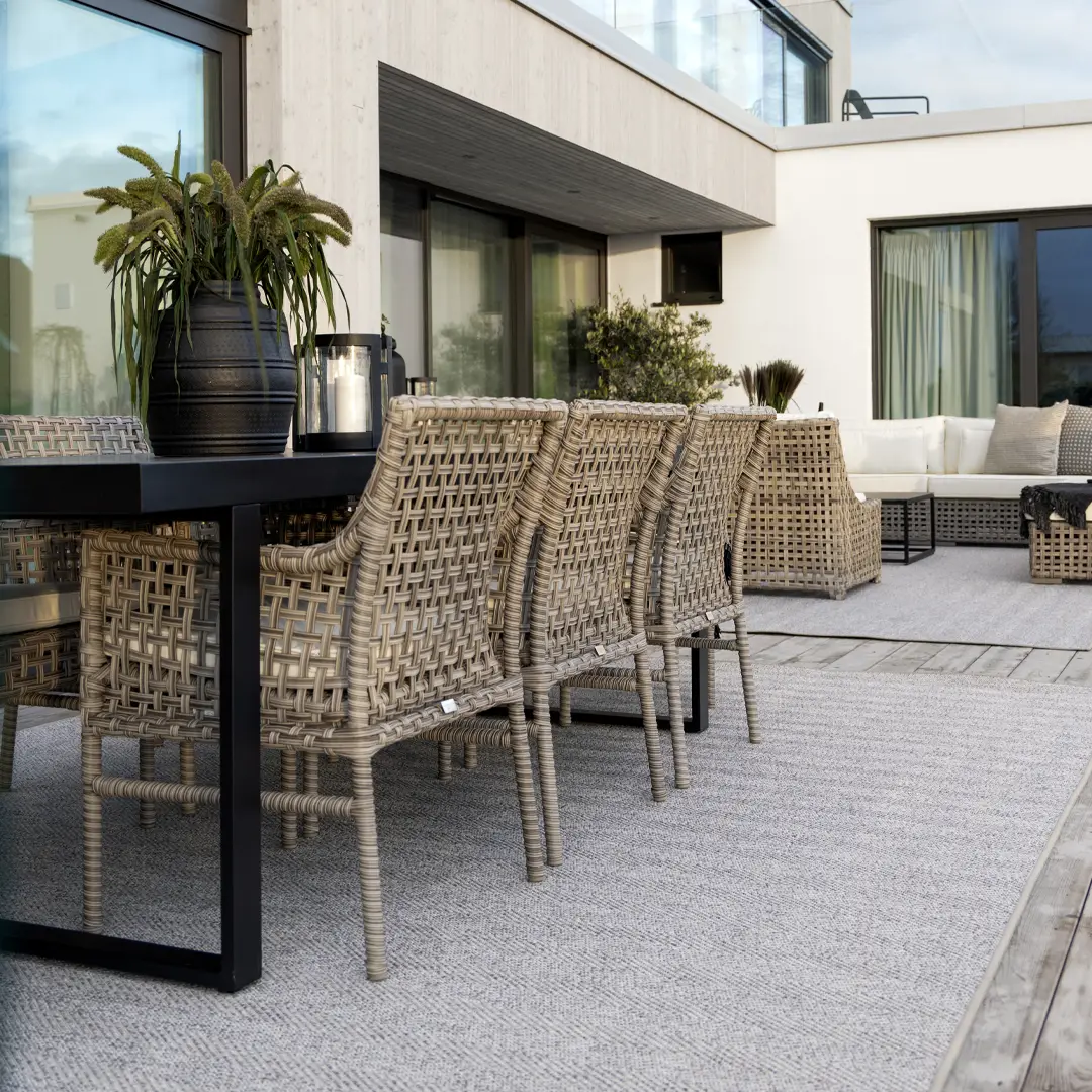 Romano-dining_table_ Modern outdoor patio with wicker chairs and plants
