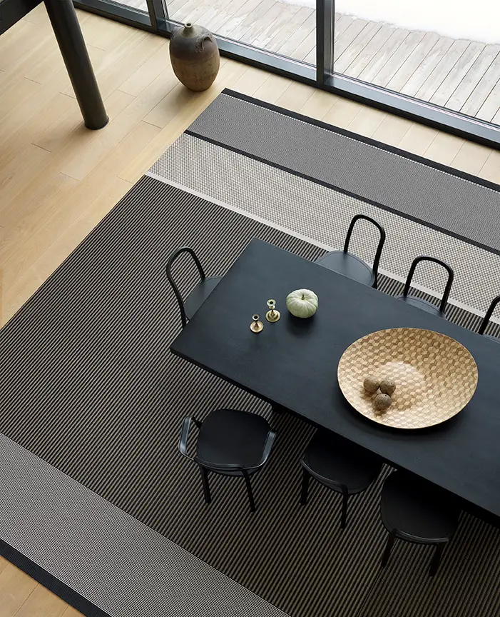 Modern dining room with black table and striped rug