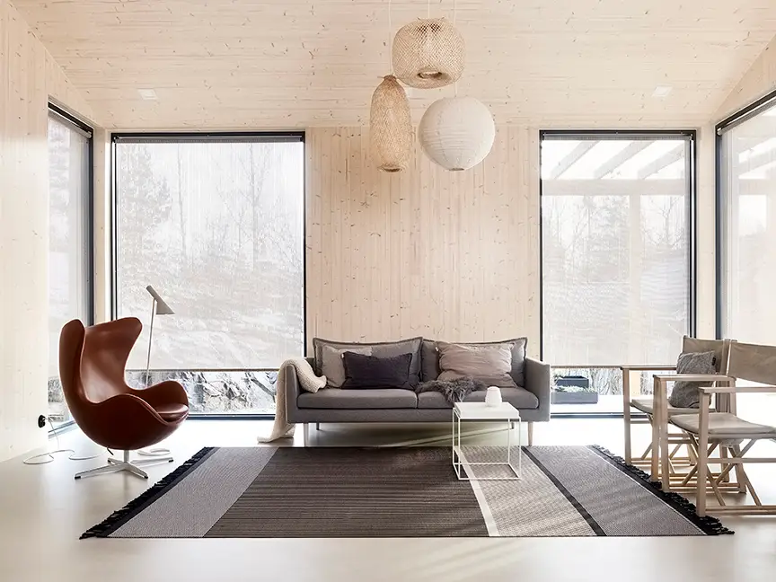 Modern minimalist living room with natural light and snow view