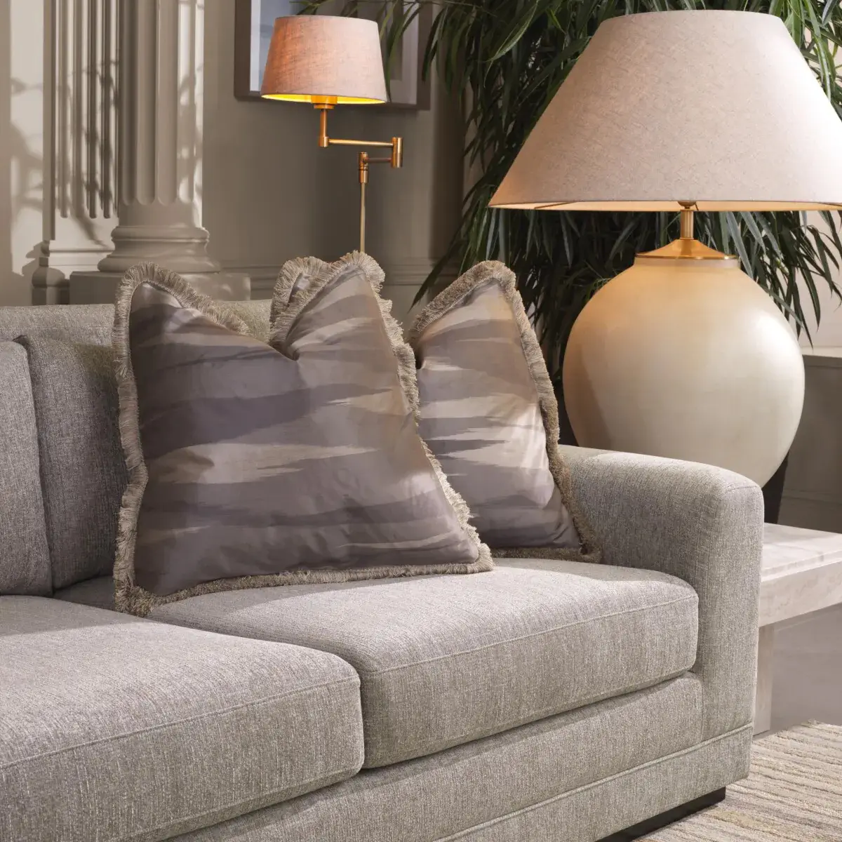Elegant sofa with decorative pillows near a floor lamp