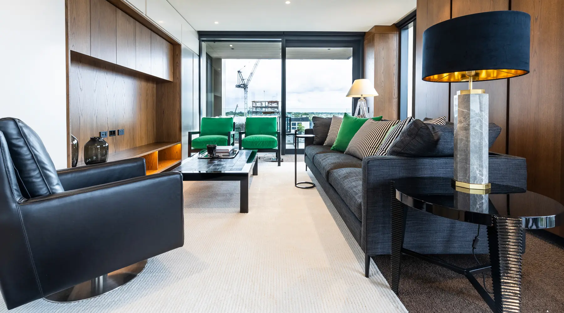 Modern living room with green chairs and city view