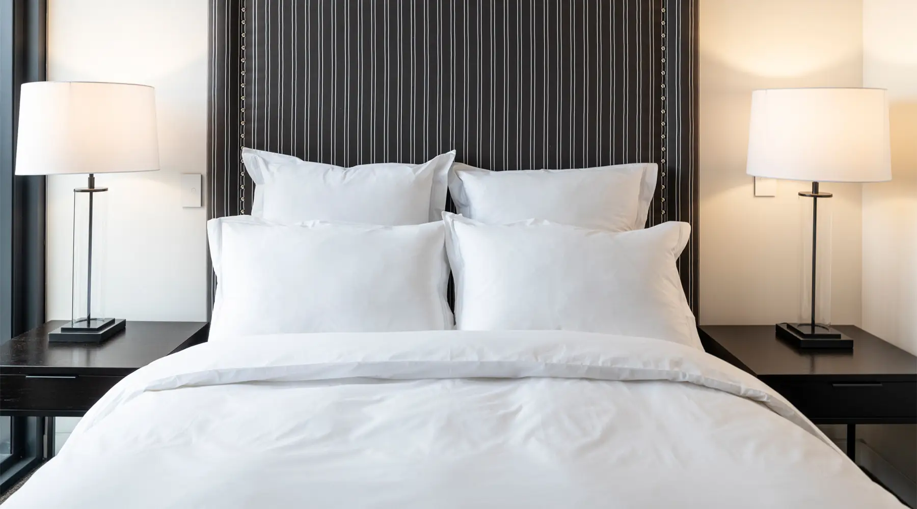 Elegant bedroom with white bedding and striped headboard