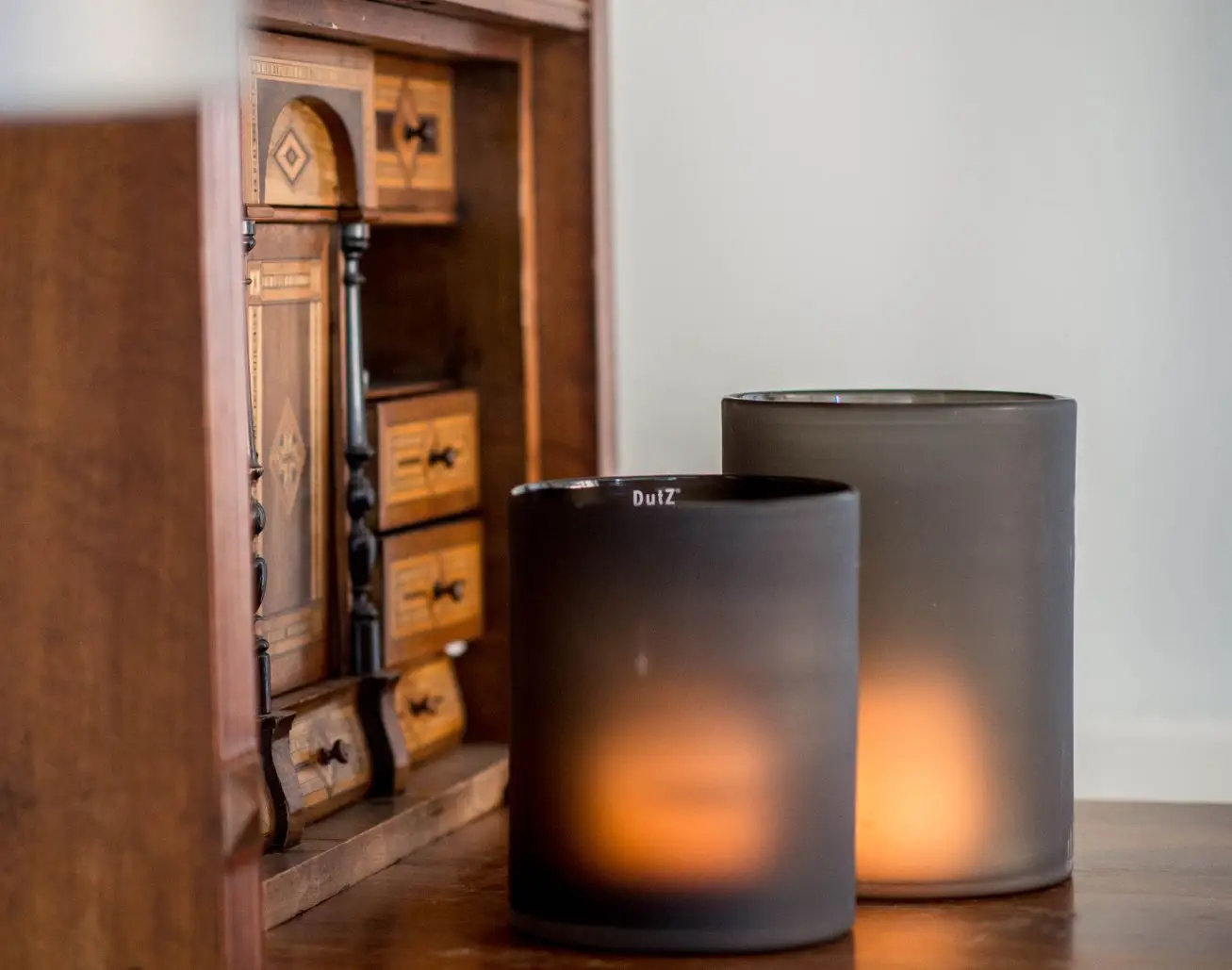 Candles glowing by antique wooden mini-cabinet