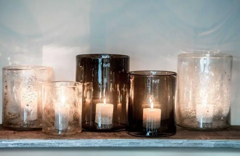 Various lit candles in decorative glass containers