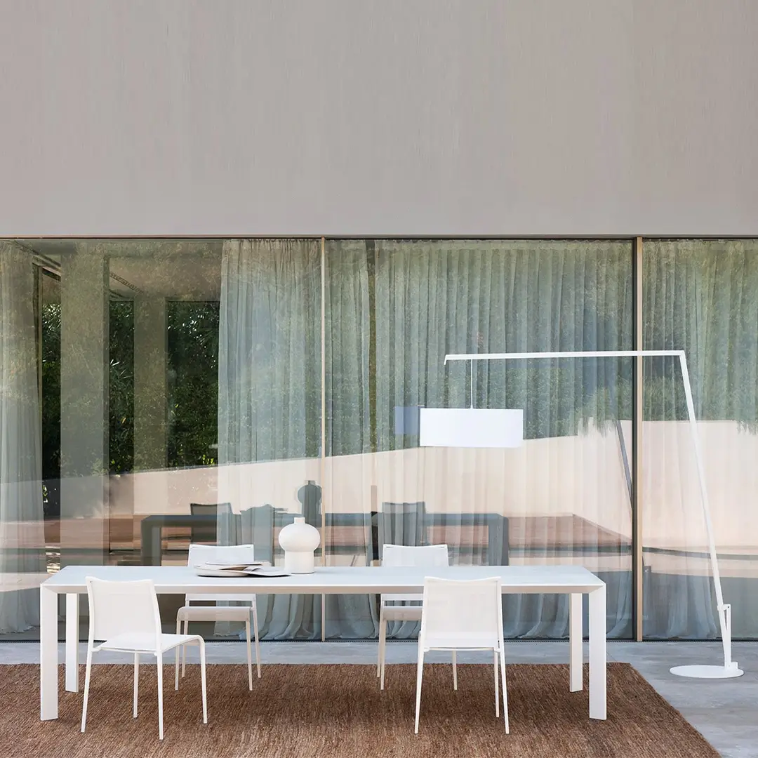 Minimalist dining room with white furniture and large window