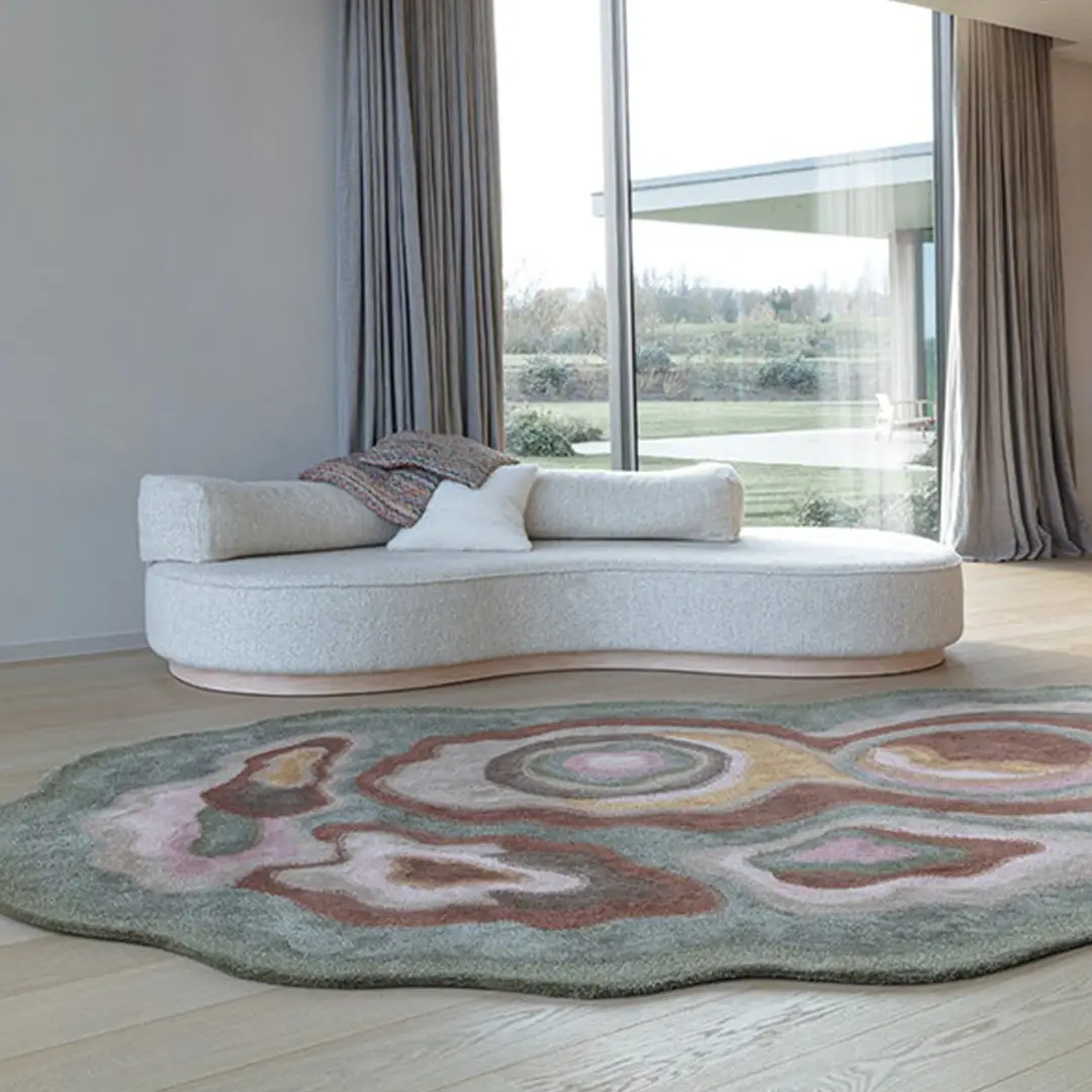 Modern round sofa and abstract rug in bright room