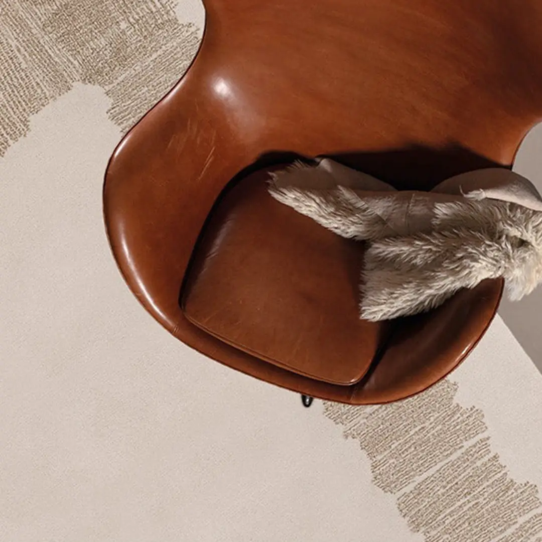 Leather chair with fluffy pillow on textured rug