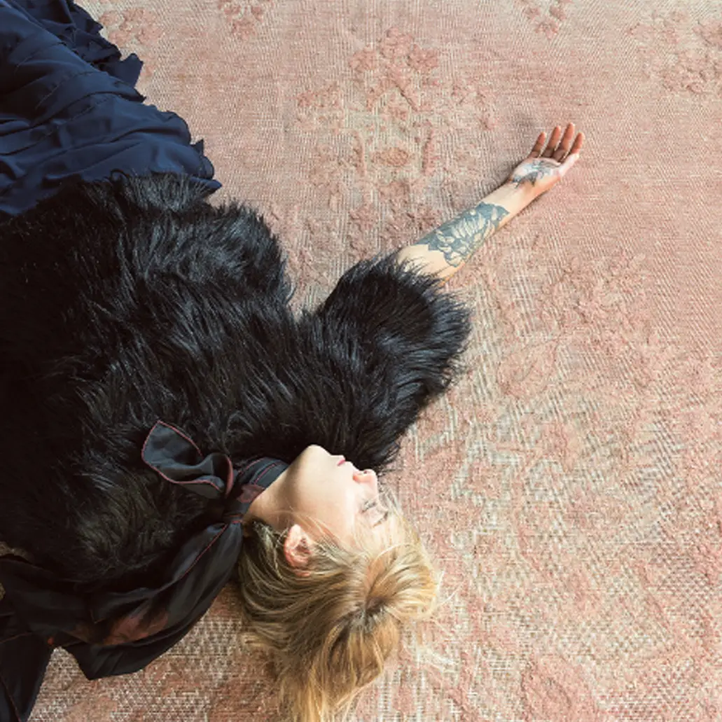 vintage_sq_5 Woman with tattoo lying on carpet wearing dark coat