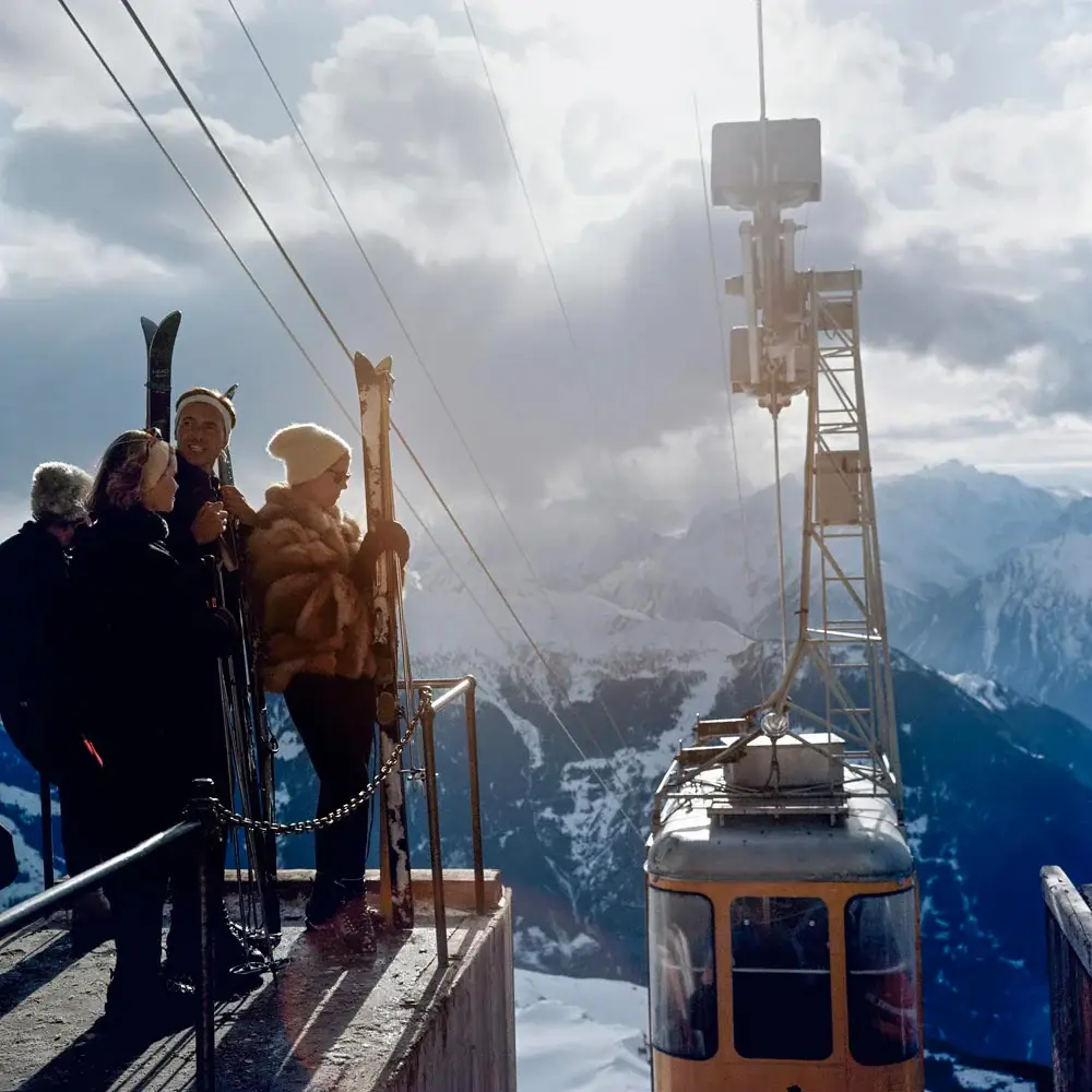 Skiers boarding cable car on snowy mountain