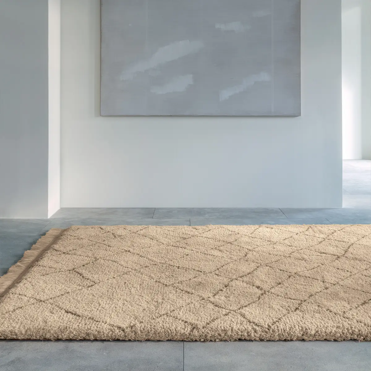 Minimalist room with beige rug and abstract wall art