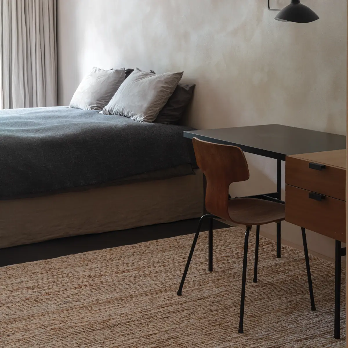 Minimalist bedroom with gray bedding and wooden desk