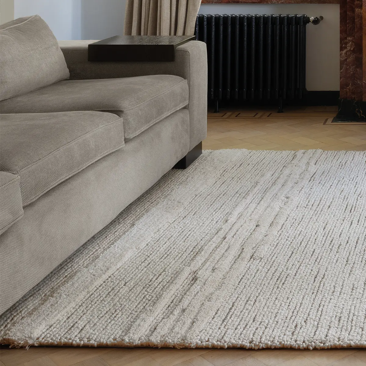 Santiago_Crystal_Clouds Elegant gray sofa and textured white rug in room