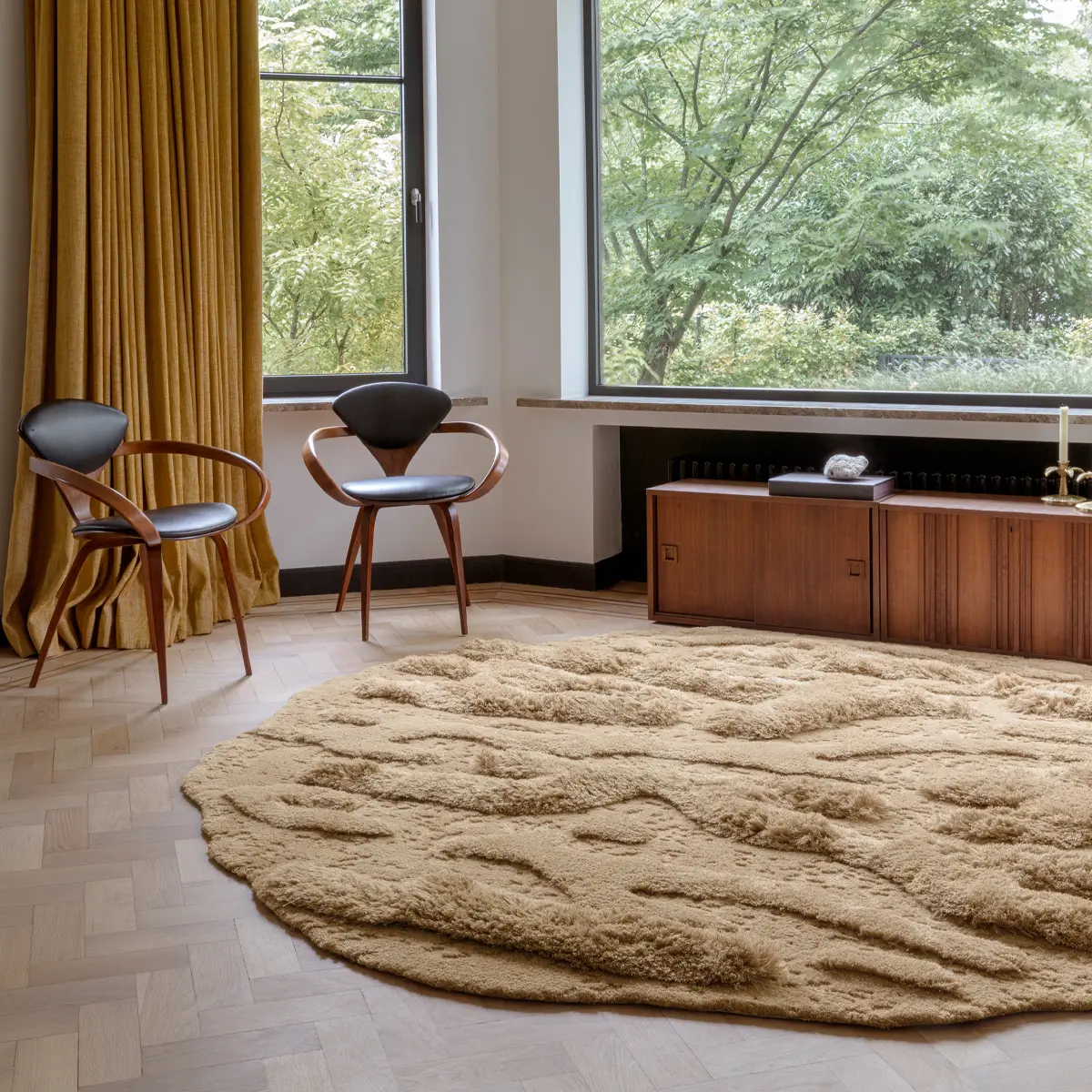 Cozy room with two chairs, large rug, and window view