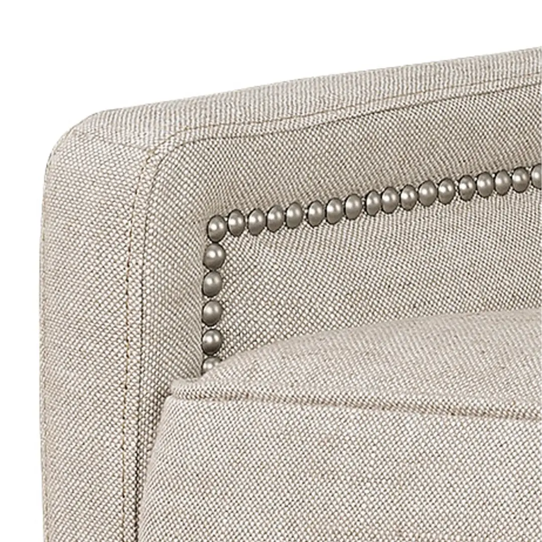Close-up of beige fabric sofa with nailhead trim