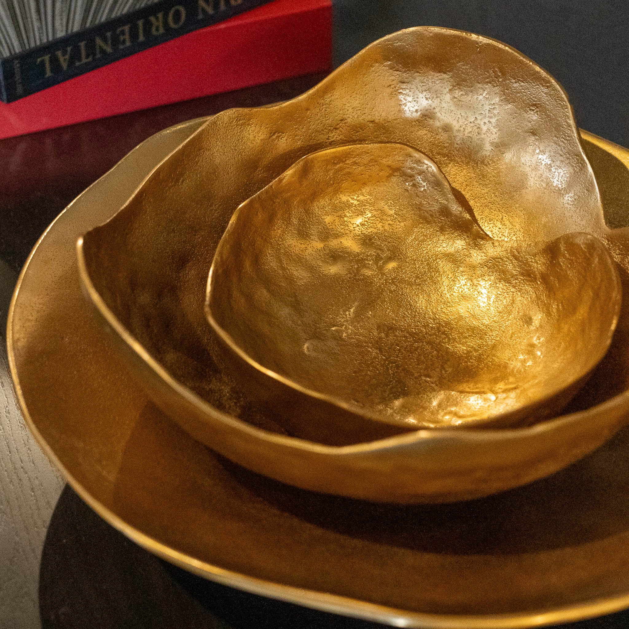 Golden textured bowls on table with books