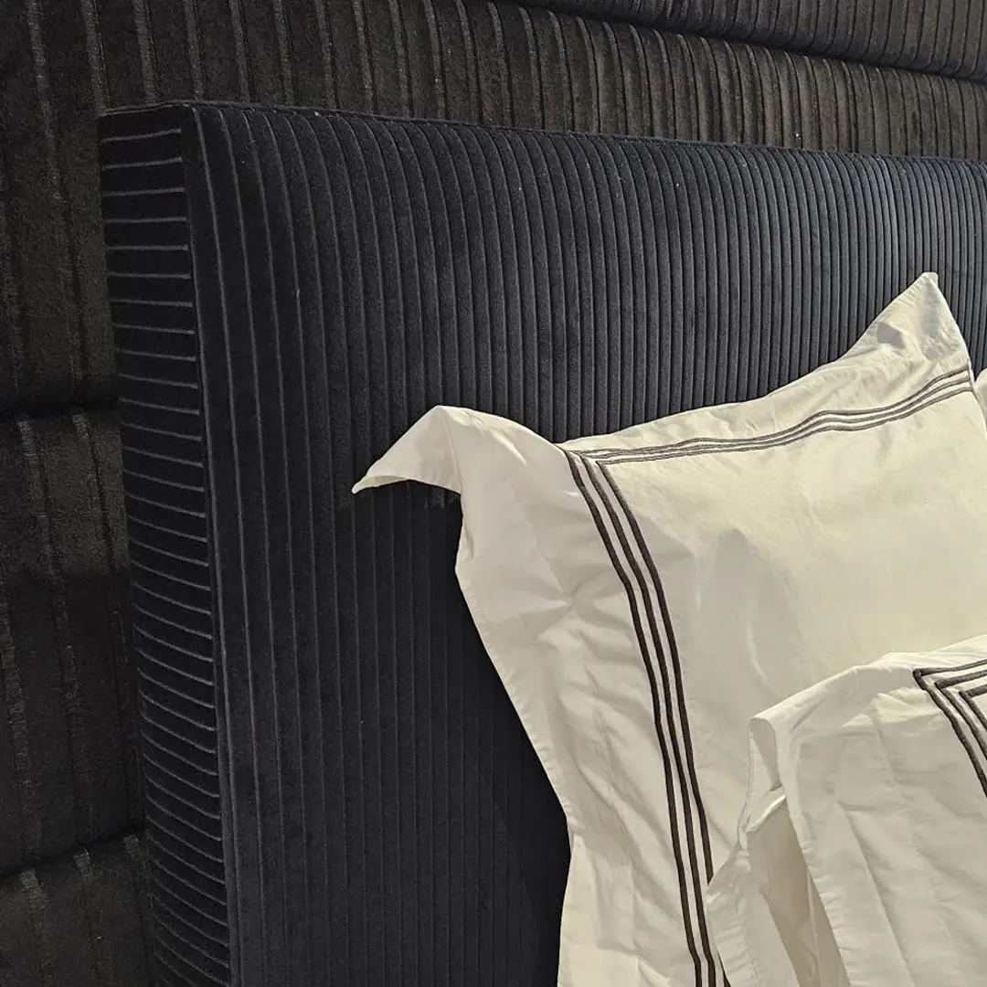 Elegant black ribbed headboard with white striped pillow