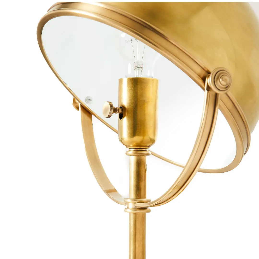 Gold floor lamp with circular shade and visible bulb